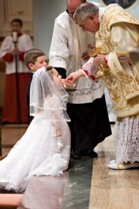 Bishop Gainer distributing First Holy Communion